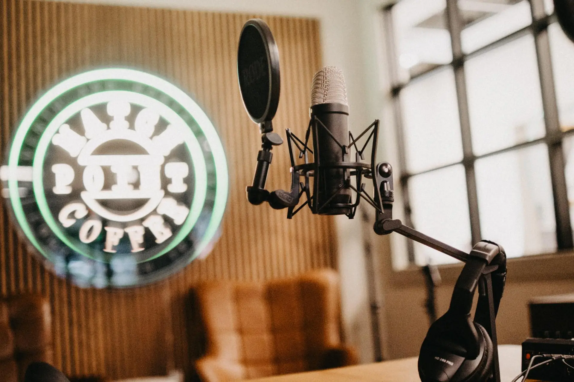 podcast mic in foreground with match point coffee neon sign in back